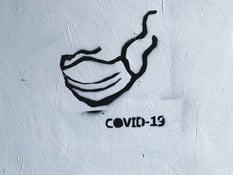 coronavirus spray painted on white wall