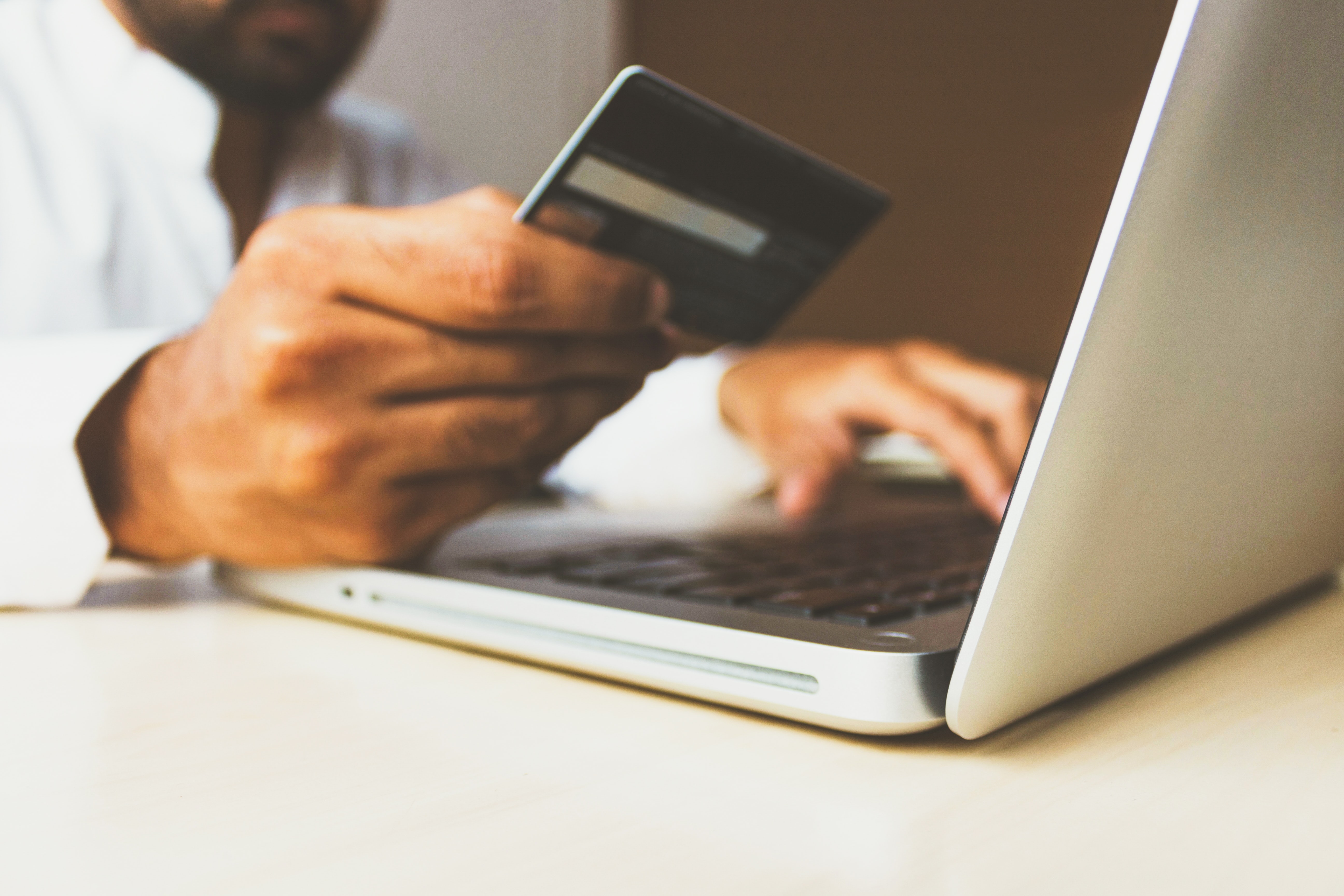 A man typing his credit card information on his laptop